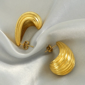 Detail of 18K gold plated hoop earrings with spiral texture on silver silk fabric