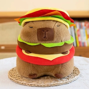 Detail of Capybara plush toy featuring a colorful burger shape on a woven mat