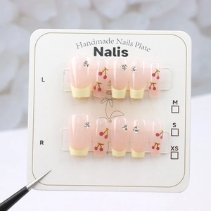 Detailliertes Set handgefertigter Kunstnägel mit roten Kirschmustern und Glitzersteinen