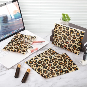 Detailed set of five leopard print EVA makeup bags on a white marble vanity desk