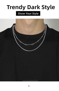 Detail of layered silver titanium steel chain necklace on model with dark style aesthetics