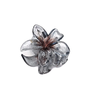 Detailed view of a 4cm translucent smoky grey plumeria hair claw clip with fine glitter