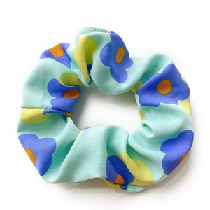 Mint green scrunchie with blue floral prints and yellow geometric patterns for women