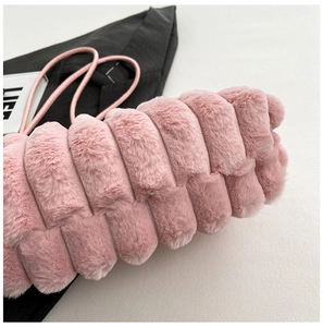 Dettaglio della borsa a mano in peluche rosa con trama a righe e tracolla coordinata
