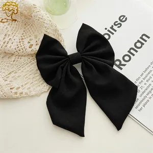Detail shot of black bow hair clip featuring thick twill fabric texture and sturdy shape