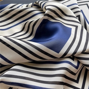 Detail of glossy faux silk fabric with elegant blue, white, and black geometric patterns