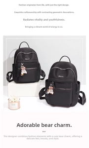 Detail of durable black oxford backpack with silver zippers and a cute toy bear pendant