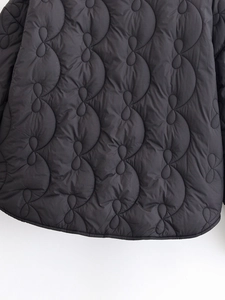 Detail of black wave quilted jacket showing intricate gourd patterns and high-quality stitching