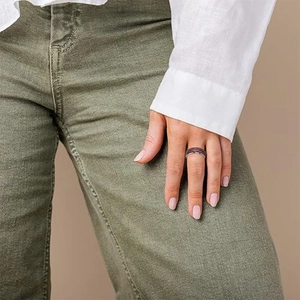 Titanium steel ring with wood inlay and turquoise stripe on a male model's finger