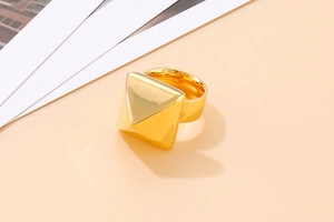 Top view of a chunky gold square pyramid ring with a polished metallic finish