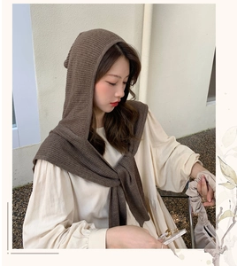 Close-up of brown knitted hooded scarf wrap showing thick texture and stylish winter drape