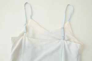 Détail des bretelles bleues réglables et du décolleté d'une robe d'été fleurie