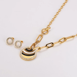 Close-up of gold stainless steel jewelry set with black and white zircon circle charms