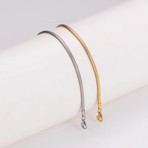 Polished stainless steel snake bone bracelets in gold and silver finish on white stand