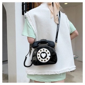 Close-up of creative retro phone crossbody bag with rotary dial and heart design in black