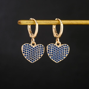18K gold plated copper heart earrings with blue zircon inlays on black background