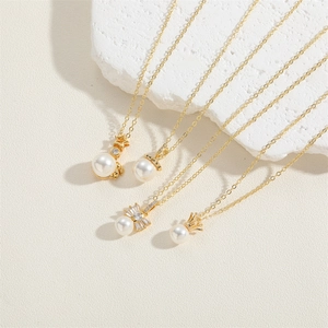French vintage gold pearl necklaces with star, crown and bow pendants on stone