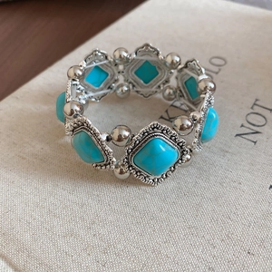Detailed macro view of vintage elastic bracelet with silver beads and green turquoise