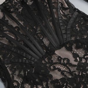 Détail macro du tissu en dentelle florale noire avec des baleines de corset en satin