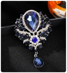 Detail of luxury crystal brooch with teardrop blue gems and silver alloy setting