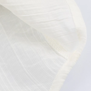 Minimalist white textured blouse showing detailed fabric weave and professional stitching