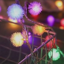 Close-up of solar star string lights with dandelion design emitting colorful warm glow