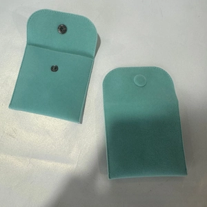 Macro detail of Tiffany blue velvet jewelry pouch featuring button closure and neat stitching