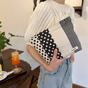 Macro detail of high-capacity polka dot canvas organizer bag with side brand label