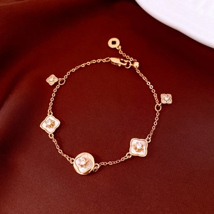 Détail macro du bracelet trèfle en or 18 carats avec nacre sur fond de soie rouge