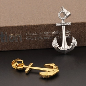 Pendentifs ancre de luxe en or 18k et argent avec cristaux sur fond de livre vintage