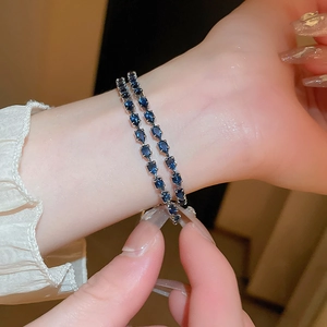 Close-up of elegant double-layer bracelets with blue pear-cut zircon on wrist