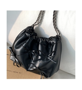 Close-up of black PU leather bucket bag with 3D bows and silver chain strap