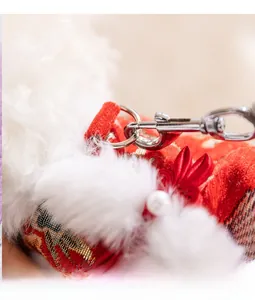 Close-up of red velvet pet garment with gold embroidery and metal D-ring for leash attachment