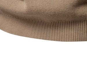 Close-up of khaki knit sweater showing high-density stitching and ribbed hem detail
