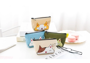 Detail of canvas coin purses with cute cat illustrations and zipper closure in four colors
