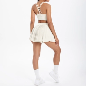 Détail du soutien-gorge de sport à dos croisé et jupe plissée courte couleur crème