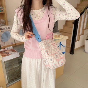 Détail d'un sac seau matelassé à fleurs avec panneaux roses et bandoulière bleue réglable