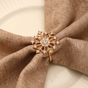 Rond de serviette flocon doré avec cristaux sur lin pour décoration de table chic