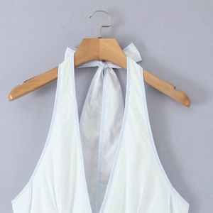Weißes Neckholder-Minikleid mit hellblauem Saum an einem Holzbügel hängend