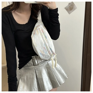 Close-up of white shoulder bag featuring colorful stripe embroidery and woven zipper pull