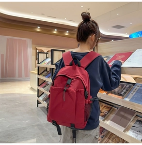 Dunkelroter Nylon-Rucksack mit gepolsterten Trägern in einer gemütlichen Buchhandlung