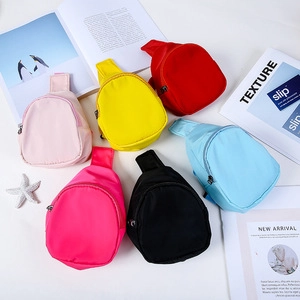 Flat lay of colorful nylon mini chest bags in red, yellow, pink, and blue on white background