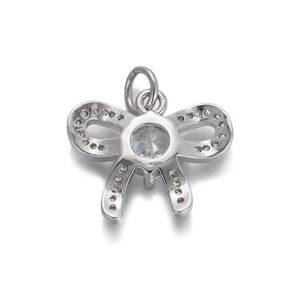 Macro shot of silver bow pendant with a central round crystal and pavé set small diamonds