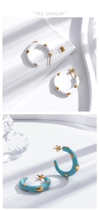 Detail of turquoise and white enamel C-shaped earrings with gold heart accents