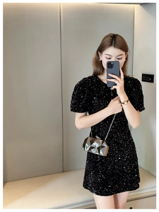 Close-up of black sequined dress with round neck and short puff sleeves for party