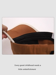 Internal view of brown cotton cap featuring black sweatband and adjustable back strap