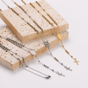 Set of four stainless steel rosary necklaces with crucifix pendants on stone blocks
