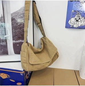 Detailed side view of khaki canvas crossbody bag with large flap and side pocket
