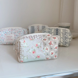 Detailed texture of floral quilted cotton makeup bags with delicate zipper and lace