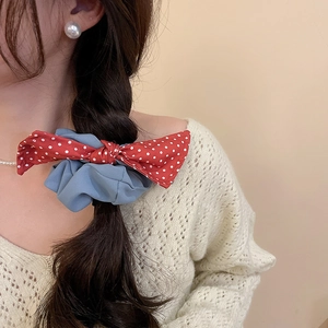 Blue fabric scrunchie with red polka dot bow shown on a braided ponytail hairstyle